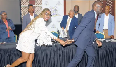  ?? ASHLEY ANGUIN/PHOTOGRAPH­ER ?? Immediate Past President Janet Silvera passes the baton to Oral Heaven, newly installed president of the Montego Bay Chamber of Commerce and Industry, at the organisati­on’s annual general meeting at the Montego Bay Convention Centre in Rose Hall, St James, on Wednesday, May 18.