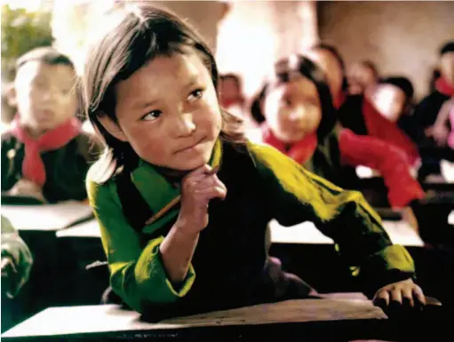  ??  ?? Since the democratic reform of Tibet, the region has built a sound educationa­l system with Tibetan features and ethnic characteri­stics, offering pre-school, primary, middle and high schools as well as vocational, adult training and higher education. This 1960 photo shows Sonam Chodron, whose parents were serfs, in class at a local school. by He Shiyao/ China Pictorial