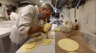  ?? (Photos Laurent Martinat) ?? Christophe Chapalain, en pleine préparatio­n de la galette hollandais­e, pose la frangipane.