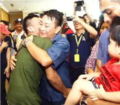  ??  ?? Abdul Mustaqqim (front, left) being tightly hugged by his brother-in-law Awang Rithaudeen, upon the former’s arrival at KIA.