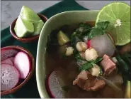  ?? PHOTO BY CATHY THOMAS ?? Pozole, made with chunks of pork in a spicy broth and garnished with sliced limes and radishes, is a warming dish.