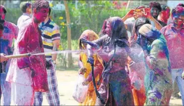  ?? PHOTOS: AH ZAIDI & DEEPAK SHARMA/HT ?? (Anticlockw­ise from above) members of the erstwhile Kota royal family play Holi in Kota on Monday; police officials celebrated the festival in Jaipur.