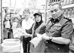  ??  ?? Jainab (second right), Yahya (right) and CKS Donggongon assistant manager Henry Chong (third right) with packets of subsidized cooking oil during the price check at CKS Supermarke­t Donggongon yesterday.