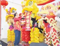  ??  ?? CHUA menerima kain rentang Gong Xi Fa Cai daripada penari singa.