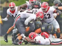  ?? THE ASSOCIATED PRESS ?? Georgia defenders Davin Bellamy (17), Tyler Clark (52) and Roquan Smith (3) stuff Vanderbilt running back Khari Blasingame during Saturday’s 45-14 win by the Bulldogs. The Commodores were held to 236 total yards, but Georgia defenders were not happy...