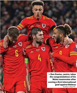  ?? Bradley Collyer/PA ?? > Ben Davies, centre, takes the congratula­tions of his
Wales teammates after scoring a first internatio­nal
goal against Belarus