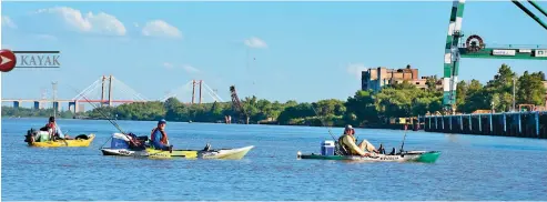  ??  ?? Arriba: toda estructura es imponente cuando se la mira desde el ras del agua; de fondo, el puente Zárate-Brazo Largo. Derecha: almuerzo en el point Aguas Calientes de Campana, con integrante­s de La Tribu, pesca deportiva.