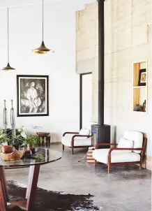  ??  ?? living area
‘These armchairs are so deep, you have no choice but to lean back and relax,’ says Eva. A tall-chimneyed contempora­ry wood burner emphasises the soaring height of the space. Get the look The wood burner is by Morsø. The armchairs are from...