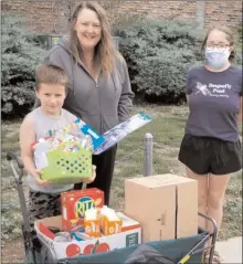  ?? Special to The Herald ?? Dragonfly Pond Society practicum student Tina Gamache (right) delivers care packages Thursday to member Michelle Berg and her grandson Dominic.