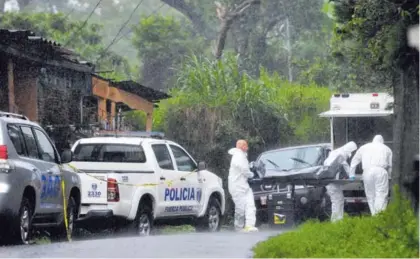  ?? MELISSA FERNÁNDEZ SILVA ?? Agentes del OIJ sacaron los dos cuerpos bajo el intenso aguacero que cayó en la tarde.