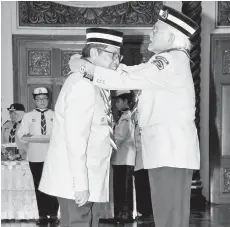  ??  ?? TUN Taib (kanan) menganuger­ahkan Bintang Semangat Padi Perak kepada Ketua Menteri.