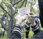  ?? ABEL URIBE/CHICAGO TRIBUNE ?? At the end of a march against police brutality Saturday in Grant Park, activists leave positive notes hanging on flowering trees.