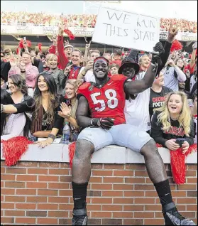  ?? CURTIS COMPTON / CCOMPTON@AJC.COM ?? Georgia football fans (celebratin­g with Sterling Bailey after the victory over Georgia Tech last season) probably are mostly OK with the fee. But what about non-fans?