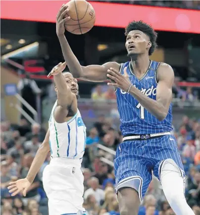  ?? JOHN RAOUX/AP PHOTOS ?? The Magic’s Jonathan Isaac, right, drives to the basket past Charlotte’s Kemba Walker on Friday night at Amway Center.