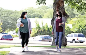  ??  ?? South Arkansas Community College students Amy Lee, left, and Savanna Morgan, both in protective masks, walk on the college’s West Campus on Monday, the first day of the fall semester at SouthArk. COVID pandemic-related health safety protocols at the college include required wearing of such masks by all students, visitors and personnel, as well as social distancing, persistent sanitizing and other procedures. (Contribute­d)