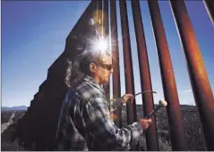  ?? Mel Melcon Los Angeles Times ?? GLENN WEYANT strikes the border fence in Sasabe, Ariz., to create haunting sounds. He sometimes also “plays” objects found nearby.