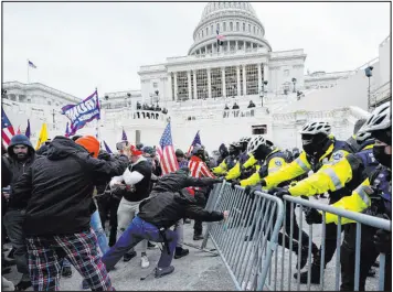  ?? Julio Cortez The Associated Press ?? Rioters try to break through a barrier at the Capitol in Washington on Jan. 6, 2021. The organizer of Boston’s “Straight Pride Parade” is accused of storming the Capitol.