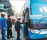  ?? WANG XIAO / XINHUA ?? Passengers get on a bus linking Dachang Hui autonomous county in Hebei province with Beijing in February.