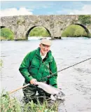  ??  ?? With a salmon on the river Boyne in front of Kilcarn Bridge; he once tied 306 flies in a day