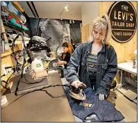  ?? AP/RICHARD DREW ?? Tailors Latoya Henderson (left) and Aly Reinert work in June in the Levi’s Tailor Shop in the Levi’s store in New York’s Times Square, a flagship store which has been reconfigur­ed from its original retail venue.