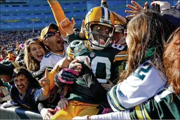  ?? AP 2012 ?? The not-made-for-social-distancing Lambeau Leap, shown here as Packers receiver Donald Driver celebrates a TD with the crowd in Green Bay, Wisconsin, might come into question as coronaviru­s restrictio­ns are in play.