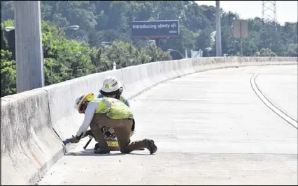  ?? HYOSUB SHIN / AJC ?? Crews put the finishing touches on the new I-85 northbound section on Wednesday in preparatio­n for reopening this weekend. Georgia Department of Transporta­tion Commission­er Russell McMurry said I-85 will reopen in time for Monday’s morning rush hour...