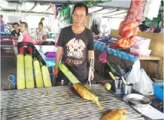  ??  ?? A trader selling barbecued fish.
