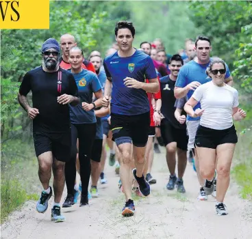  ?? SEAN KILPATRICK/THE CANADIAN PRESS ?? Prime Minister Justin Trudeau, Defence Minister Harjit Singh Sajjan and Foreign Affairs Minister Chrystia Freeland go for an early jog with troops at Adazi Military Base in Kadaga, Latvia, on Tuesday.