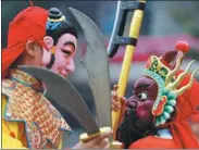  ??  ?? Pupils rehearse a Nuo Opera play at Mashan Primary School.