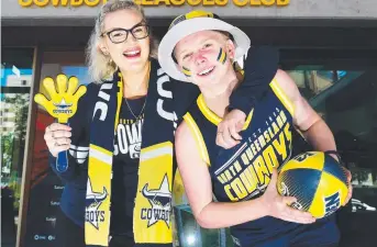  ?? TRUE COLOURS: Emma Pesl and Drew Boyd in front of Cowboys Leagues Club which is expecting a big crowd for tomorrow night’s match. Picture: SHAE BEPLATE ??