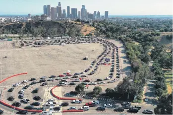  ?? MARIO TAMA/GETTY IMAGES ?? Cars line up for COVID-19 tests at Dodger Stadium in Los Angeles. It’s uncertain if fans will line up for games in 2020.