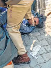  ??  ?? Police pin down a farmer during pitched battles with goons, allegedly hired by a political party