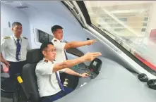  ?? YANG YONGQUAN / XINHUA ?? Chinese staff members help train an assistant driver from Laos (right) to prepare for the departure of the first Vientiane to Kunming passenger train at Vientiane Railway Station, Laos, on April 13.