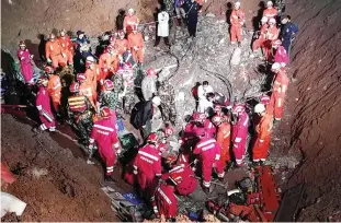  ??  ?? SHENZHEN, Guangdong: Rescuers search for survivors at the site where a giant flow of mud and constructi­on waste engulfed buildings in Shenzhen, Guangdong province yesterday. —AFP