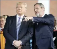  ?? THE ASSOCIATED PRESS ?? President Donald Trump stands with Liberty University President Jerry Falwell Jr. in Lynchburg, Va. Falwell, an early backer of Trump, said the president had made a “bold truthful statement” about the demonstrat­ion. Falwell said the president’s remarks...