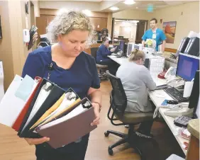  ?? STAFF PHOTO BY TIM BARBER ?? Nurse Rachel Wilcoxon prepares to file several patient charts Friday at the sixth floor nurses’ station for cardiac surgery patients at CHI Memorial.