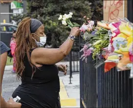  ?? STEVE SCHAEFER / FOR THE AJC ?? People who arrived Sunday at the Wendy’s helped with cleanup, while some came to look and others placed flowers to start a memorial.