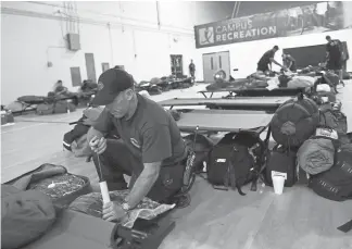  ?? RJ Sangosti, The Denver Post ?? Denver’s Erik Herbst, a member of Colorado Task Force One, gets his gear ready as he and the team prepare Friday for search and rescue operations during Tropical Storm Florence in Pembroke, N.C. Pembroke is about 80 miles inland from the coast. Colorado Task Force One is based out of West Metro Fire Rescue in Lakewood.