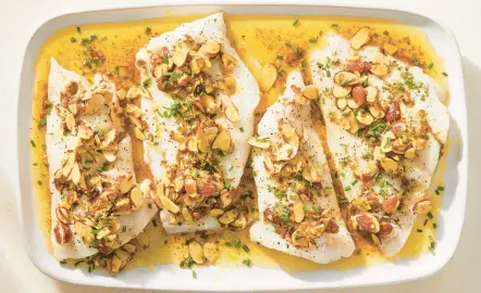  ?? JULIA GARTLAND/THE NEW YORK TIMES ?? Fish almondine is a nutty variation on a French classic, sole meuniere. Any fish works, particular­ly lean flaky fillets, for this roasted dish.