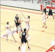  ?? Staff photograph by Mark Humphrey ?? Pea Ridge senior Carson Rhine draws three defenders to him then dumps the ball off to teammate Wes Wales for an easy inside bucket. The Blackhawks lost in triple overtime, 65-63, on Tuesday, Dec. 18, in Cardinal Arena.