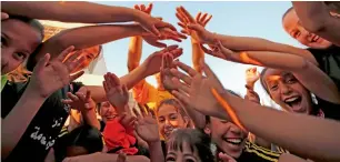  ?? AFP ?? Palestinia­n girls celebrate during a football training session with their coach Rajaa Hamdan (unseen) in the northern West Bank village of Deir Jarir, near Ramallah.