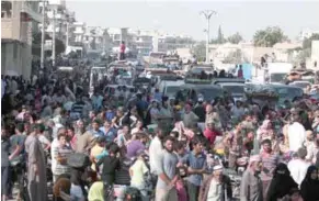  ?? – Reuters ?? RESCUED: Civilians gather after they were evacuated by the Syria Democratic Forces (SDF) fighters from an IS-controlled neighbourh­ood of Manbij, in Aleppo, Syria, on Friday.