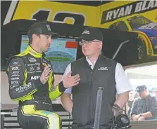  ?? AP PHOTO/PHELAN M. EBENHACK ?? Team Penske driver Ryan Blaney, left, talks with Michael Nelson, the team’s vice president of operations, in the garage during a practice session for the Daytona 500 on Feb. 18 at Daytona Internatio­nal Speedway in Daytona Beach, Fla.