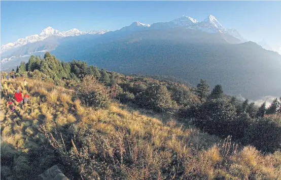  ??  ?? DANGEROUSL­Y BEAUTIFUL: Trekkers take in the sweeping sunrise at the foothills of the Dhaulagiri Range.