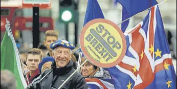  ?? AP ?? THE CIRCUS CONTINUES: Brexit protesters wave flags outside parliament in London on Tuesday.