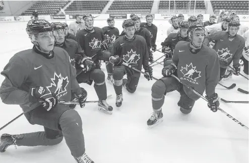  ?? RYAN REMIORZ / THE CANADIAN PRESS ?? Canada’s Dylan Strome, left, takes a knee with his teammates as they listen to instructio­ns at the world junior selection camp Sunday in Boisbriand, Que. Strome is one of five returning players on the prospectiv­e roster.
