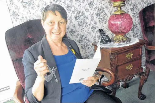  ?? TINA COMEAU ?? Yarmouth resident Sandy Dennis reads a card and holds a gift that someone sent to her to show their support.