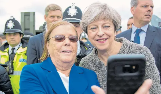  ?? EFE ?? Recuerdo. La premier británica Theresa May y una selfie con una seguidora durante un acto oficial, el sábado, en la ciudad de Liverpool.