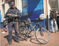  ?? Peter DaSilva / The Chronicle ?? San Francisco beat cops on bicycles detain a man on Market Street, where foot patrols will be beefed up.