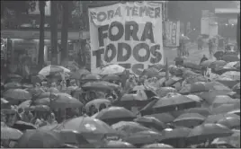  ?? The Associated Press ?? BANNER: Demonstrat­ors march against Brazil's President Michel Temer, holding a banner that reads in Portuguese "Temer Out" and "Out with everybody," on Saturday in Sao Paulo. Temer has been under siege since the newspaper O Globo reported last week...